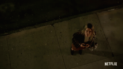 Woman On Sidewalk With Netflix Logo GIF