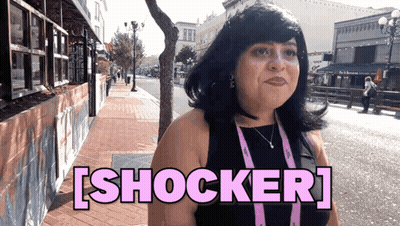 Woman On Sidewalk With Shocker In Pink Letters GIF
