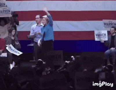 Woman On Stage Holding Warren Sign GIF