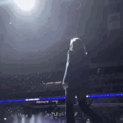 Woman On Stage In Front Of Crowd With Tl Sign GIF