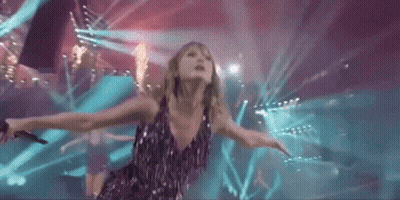 Woman On Stage With Arms Outstretched And Microphone GIF