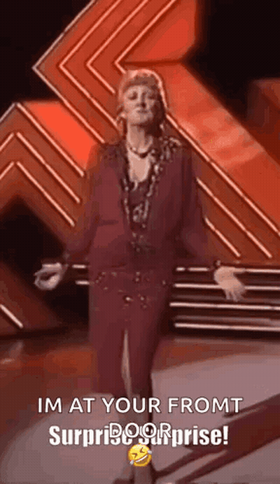 Woman On Stage With Arms Outstretched Says I'm At Your Front Surprise Surprise GIF