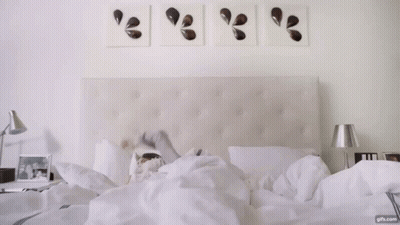 Woman On White Sheets With Nightstand Lamp GIF