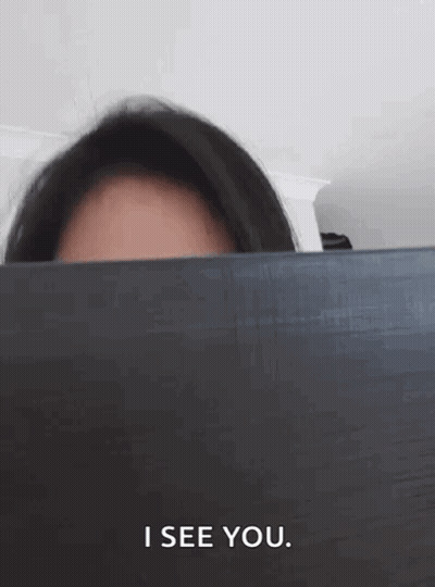 Woman Peeking Behind Laptop Saying I See You GIF