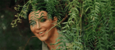 Woman Peeking From Behind Tree GIF