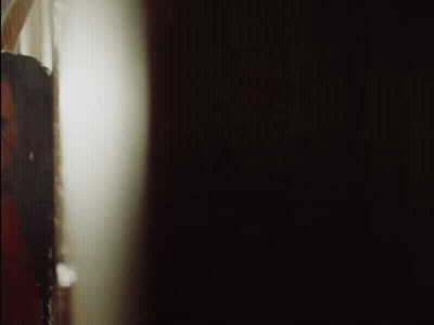 Woman Peeking From Behind Wall GIF