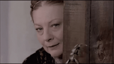 Woman Peeking From Behind Wooden Wall Smiling GIF