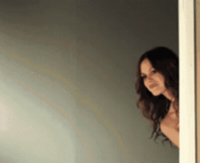Woman Peeking Out Doorway GIF