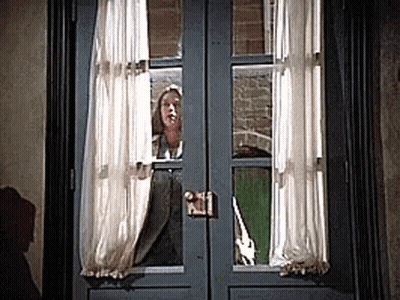 Woman Peeking Out Window With Curtains GIF