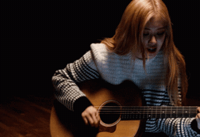Woman Playing Acoustic Guitar In Dark Room GIF