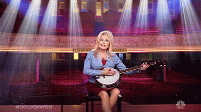 Woman Playing Banjo On Chair With NBC Logo GIF