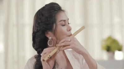 Woman Playing Flute Eyes Closed Earrings GIF