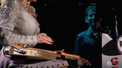 Woman Playing Guitar In Front Of NBC Podium GIF