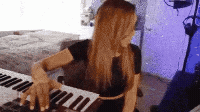 Woman Playing Keyboard In Purple Room GIF