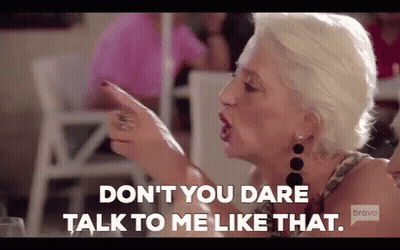 Woman Pointing at Another While Talking