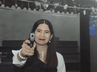 Woman Pointing Gun Wearing Pearls GIF