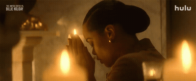 Woman Praying In Front Of Candles GIF