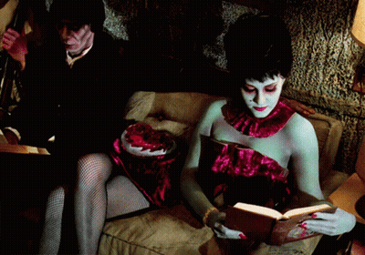 Woman Reading Book Man Holding Heart GIF