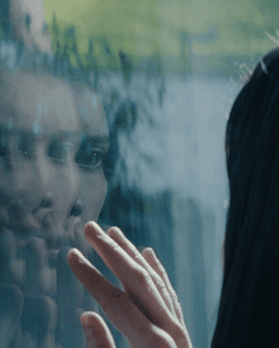 Woman Reflected In Window Touching Glass GIF