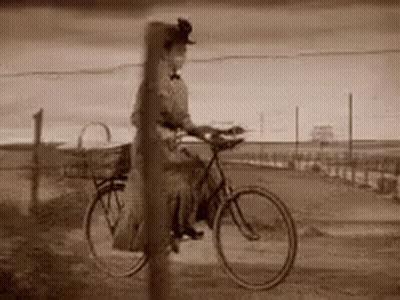 Woman Riding Bicycle On Dirt Road Black And White GIF
