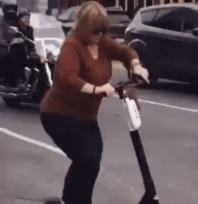 Woman Riding Scooter On Street GIF