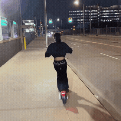 Mujer en patinete con pantalones Baby Phat GIF