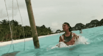 Woman Riding Swing In Pool GIF