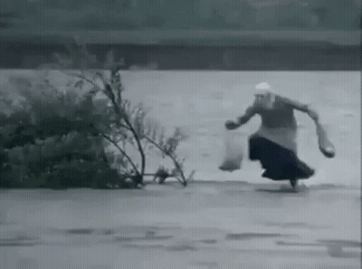 Woman Running Through Flooded Area GIF