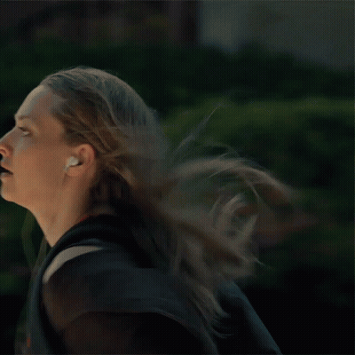 Woman Running With Headphones And Backpack GIF