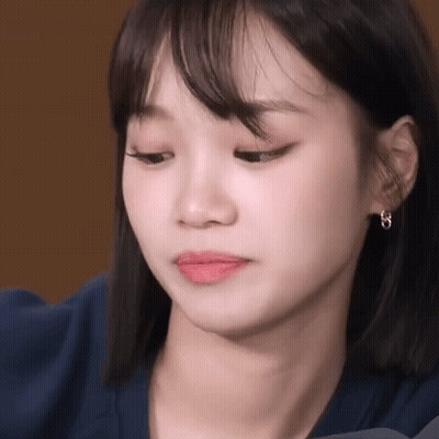 Woman's Face Close Up With Blue Shirt And Earrings GIF
