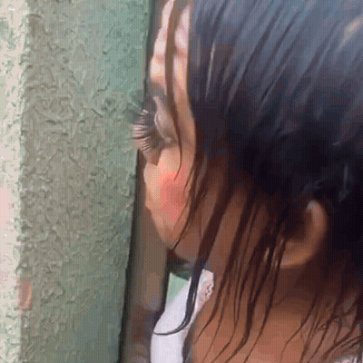 Woman's Face Close Up With Green Wall GIF