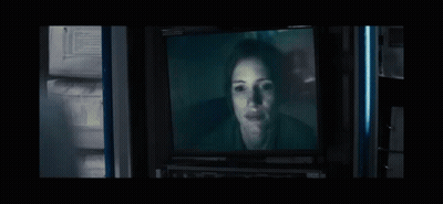 Woman's Face On TV In Dark Room GIF
