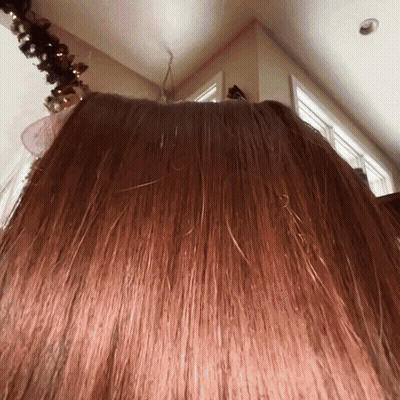 Woman's Hair Close Up With Christmas Tree GIF