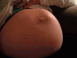 Woman's Pregnant Belly Waves As Baby Kicks GIF