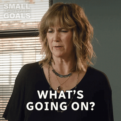 Woman Saying What's Going On In Front Of Achievable Goals Sign GIF
