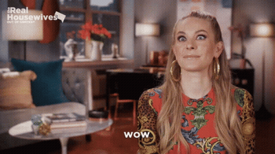 Woman Saying Wow In Front Of Real Housewives Sign GIF