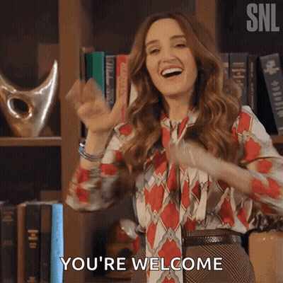 Woman Saying You're Welcome In Front Of Bookshelf GIF