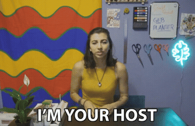 Woman Says I'm Your Host In Front Of Planter GIF
