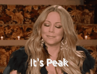 Woman Says It's Peak In Front Of Floral Backdrop GIF