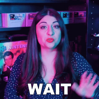 Woman Says Wait In Front Of Video Games GIF