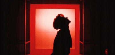 Woman Silhouette Looking Up At Sky In Red Room GIF