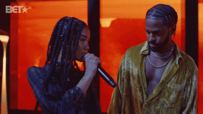 Woman Singing Into Microphone And Man With BET Logo GIF