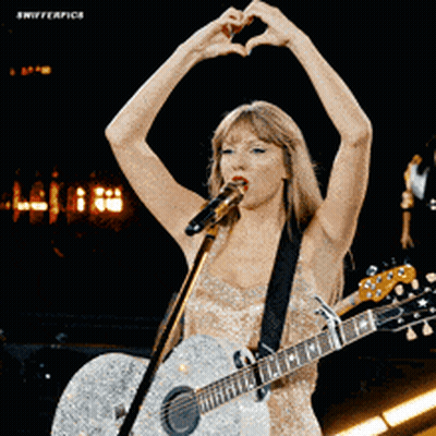 Woman Singing Into Microphone Holding Guitar Making Heart Shape GIF