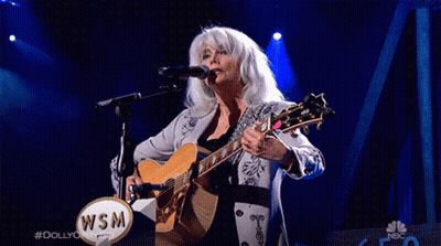 Woman Singing Into Microphone Holding Guitar With WSM Logo GIF
