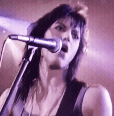 Woman Singing Into Microphone In Dark Room GIF