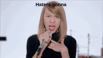 Woman Singing Into Microphone In Front Of Band Saying Hate GIF