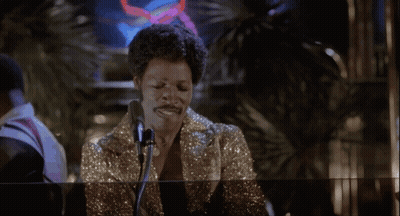 Woman Singing Into Microphone In Front Of Glass Wall GIF