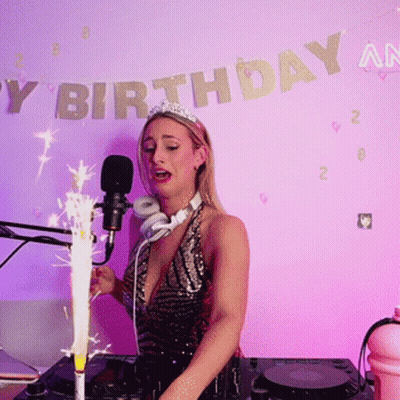 Woman Singing Into Microphone In Front Of Happy Birthday Banner GIF