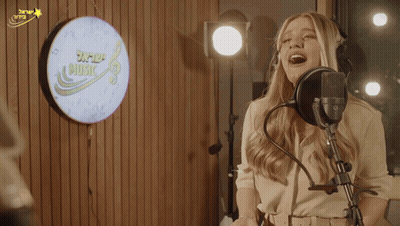 Woman Singing Into Microphone In Front Of Music Sign GIF