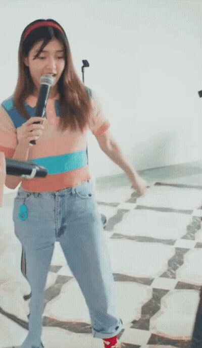 Woman Singing Into Microphone In Jeans And Headband GIF